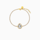 A gold-plated bracelet featuring a teardrop-shaped halo surrounded by shimmering crystals, with a adjustable chain closure.