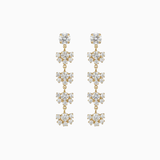 Pair of gold and crystal drop earrings on a white background