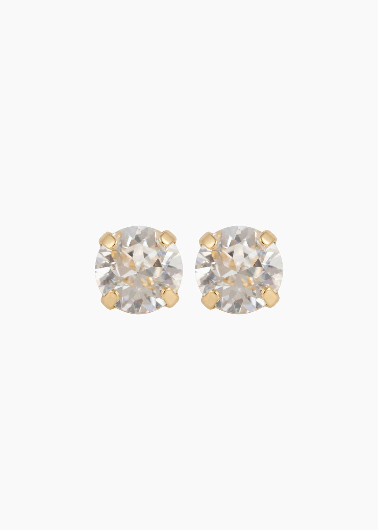 Pair of gold stud earrings with clear gemstones on a white background