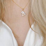 A gold-plated brass pendant necklace with a chain, featuring a floral-shaped crystal centerpiece.