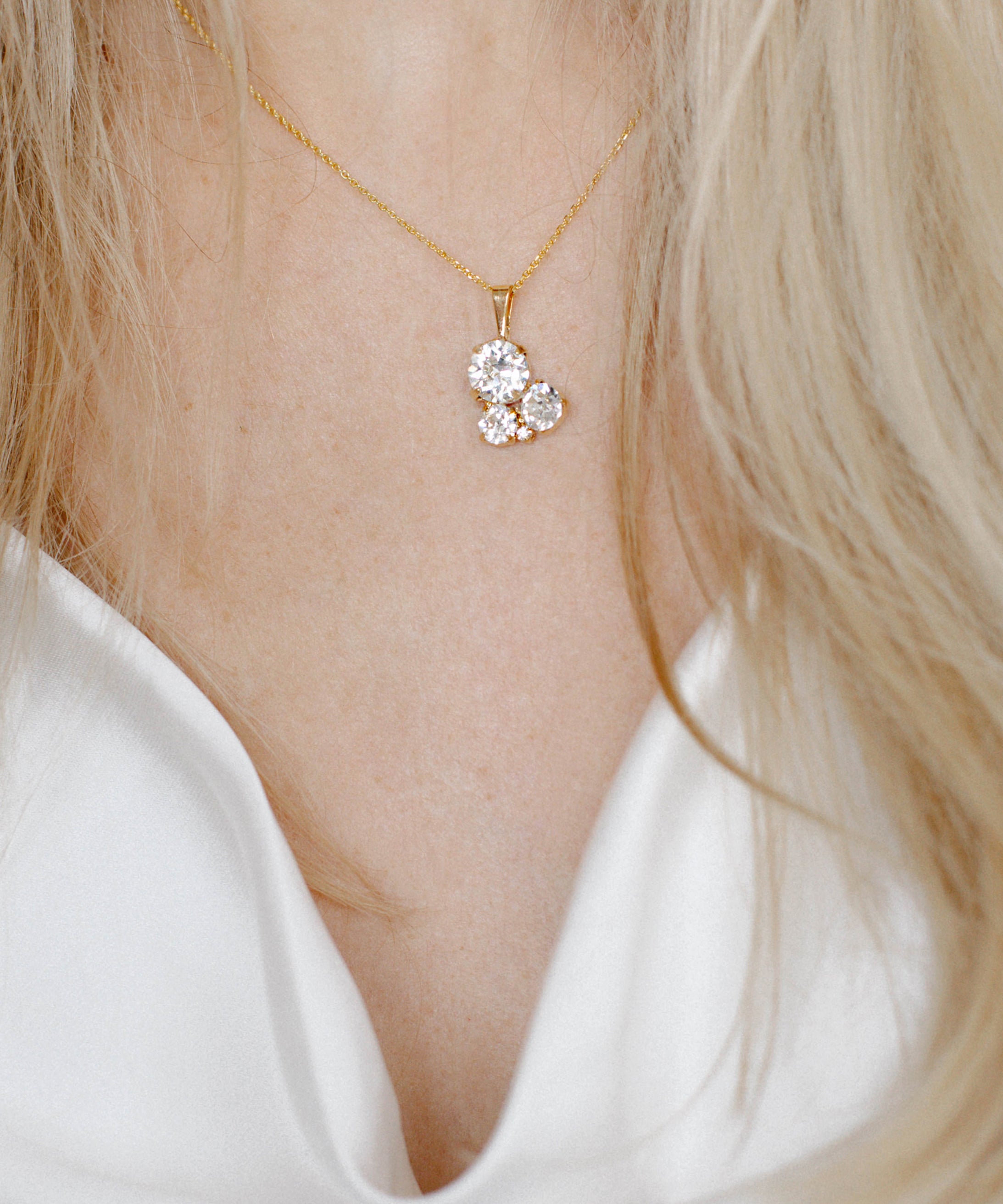A gold-plated brass pendant necklace with a chain, featuring a floral-shaped crystal centerpiece.