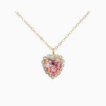 Gold necklace with a heart-shaped pink gemstone pendant on a white background