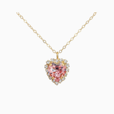 Gold necklace with a heart-shaped pink gemstone pendant on a white background