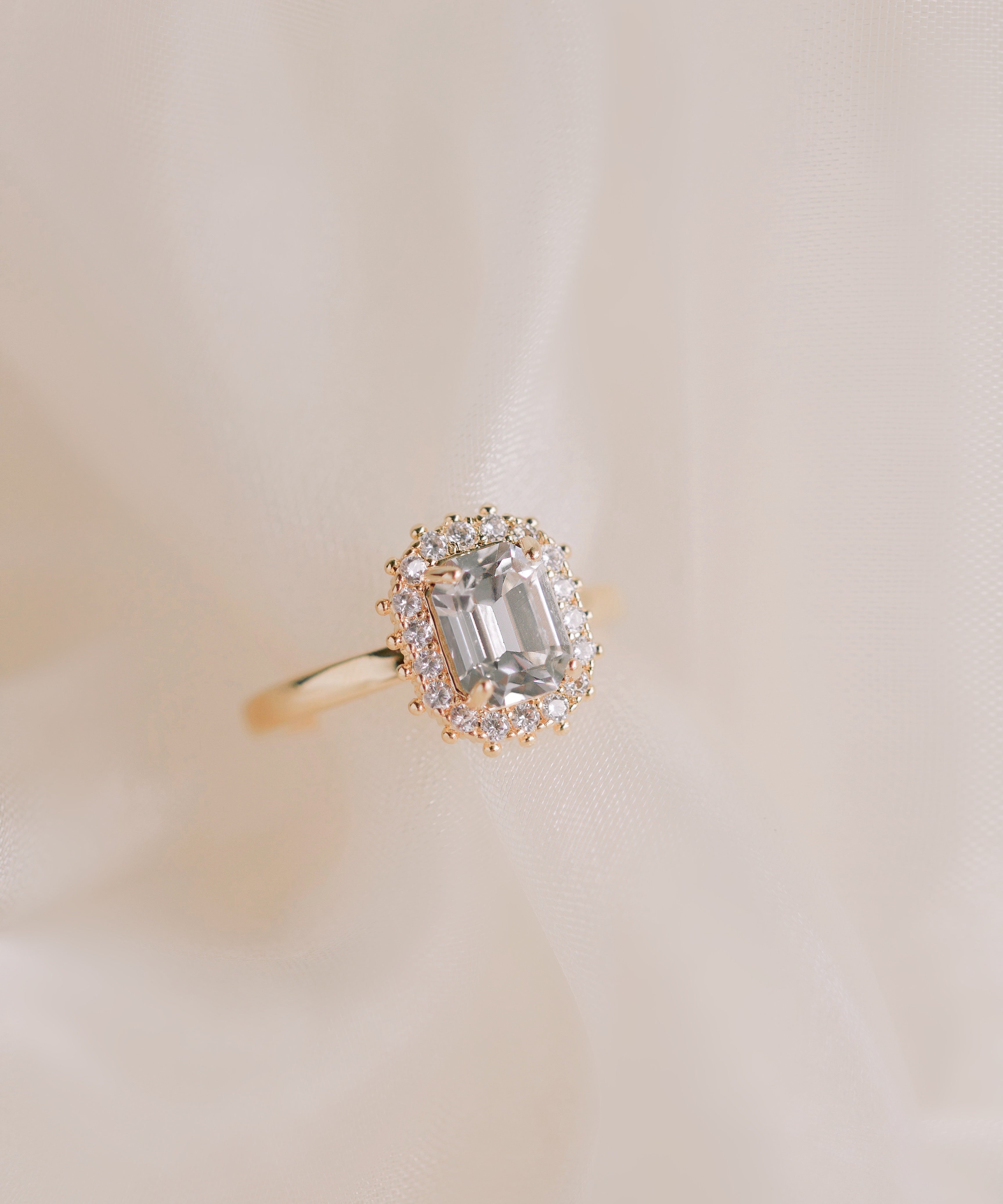 Gold ring with a diamond on a beige background