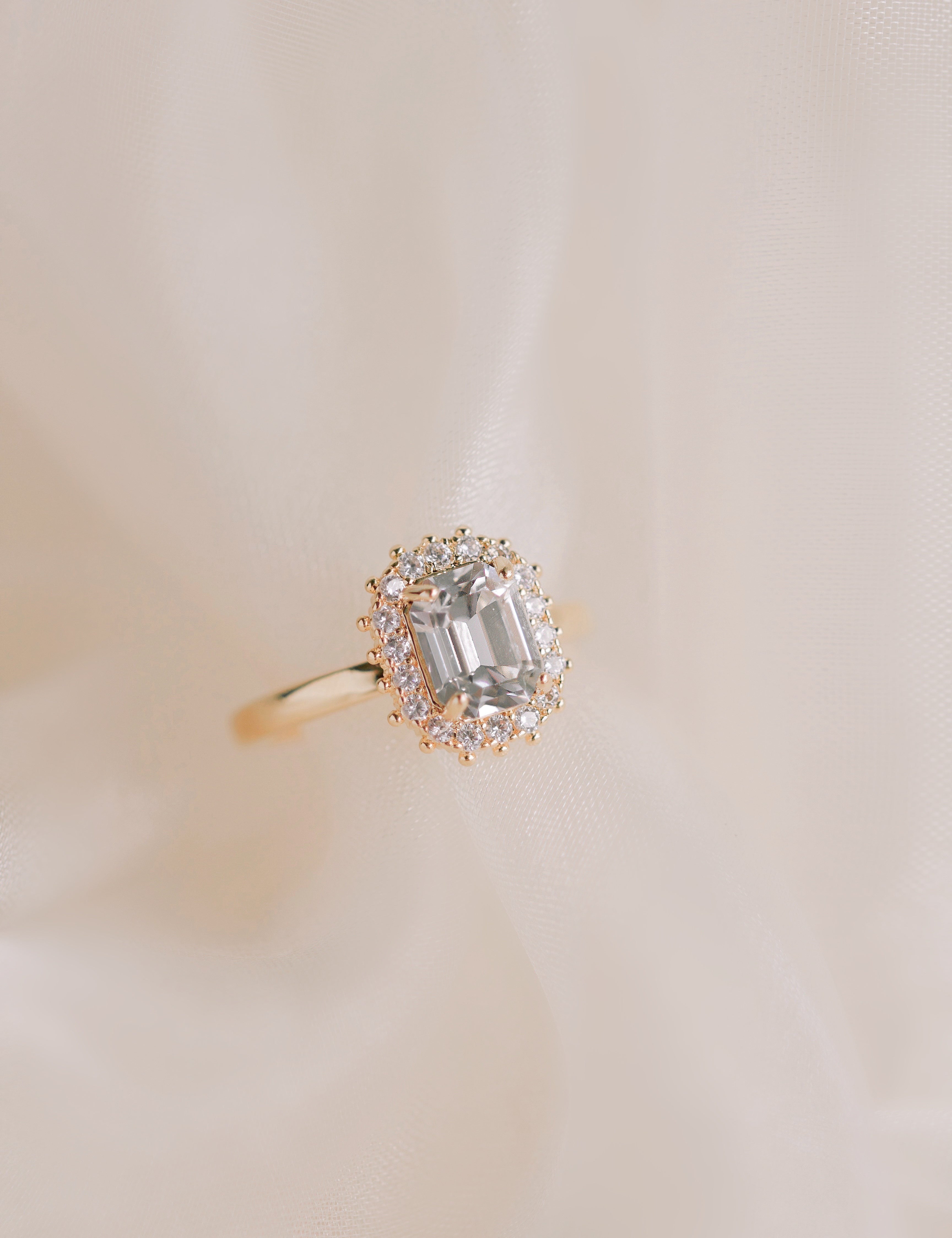 Gold ring with a diamond on a beige background
