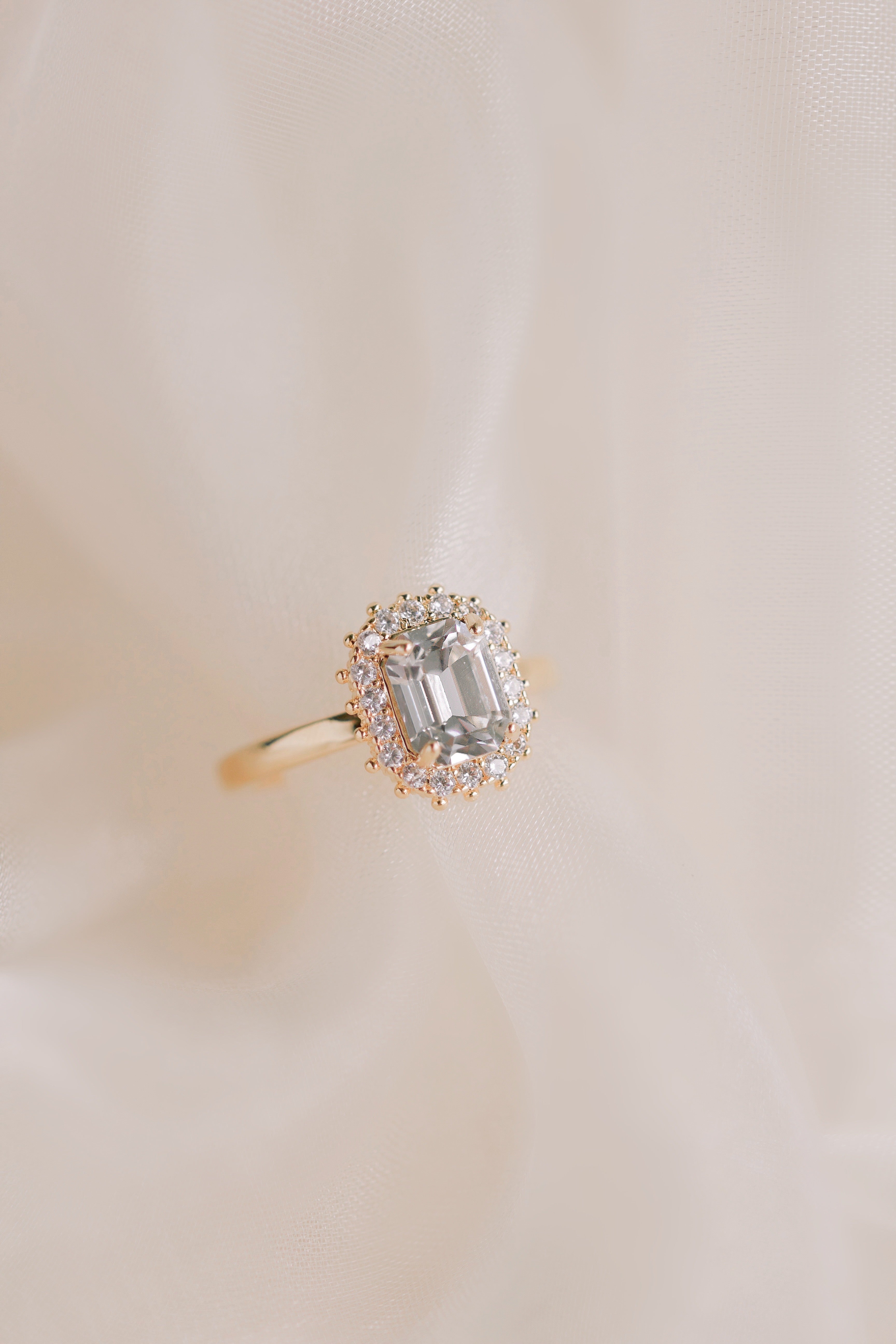 Gold ring with a diamond on a beige background