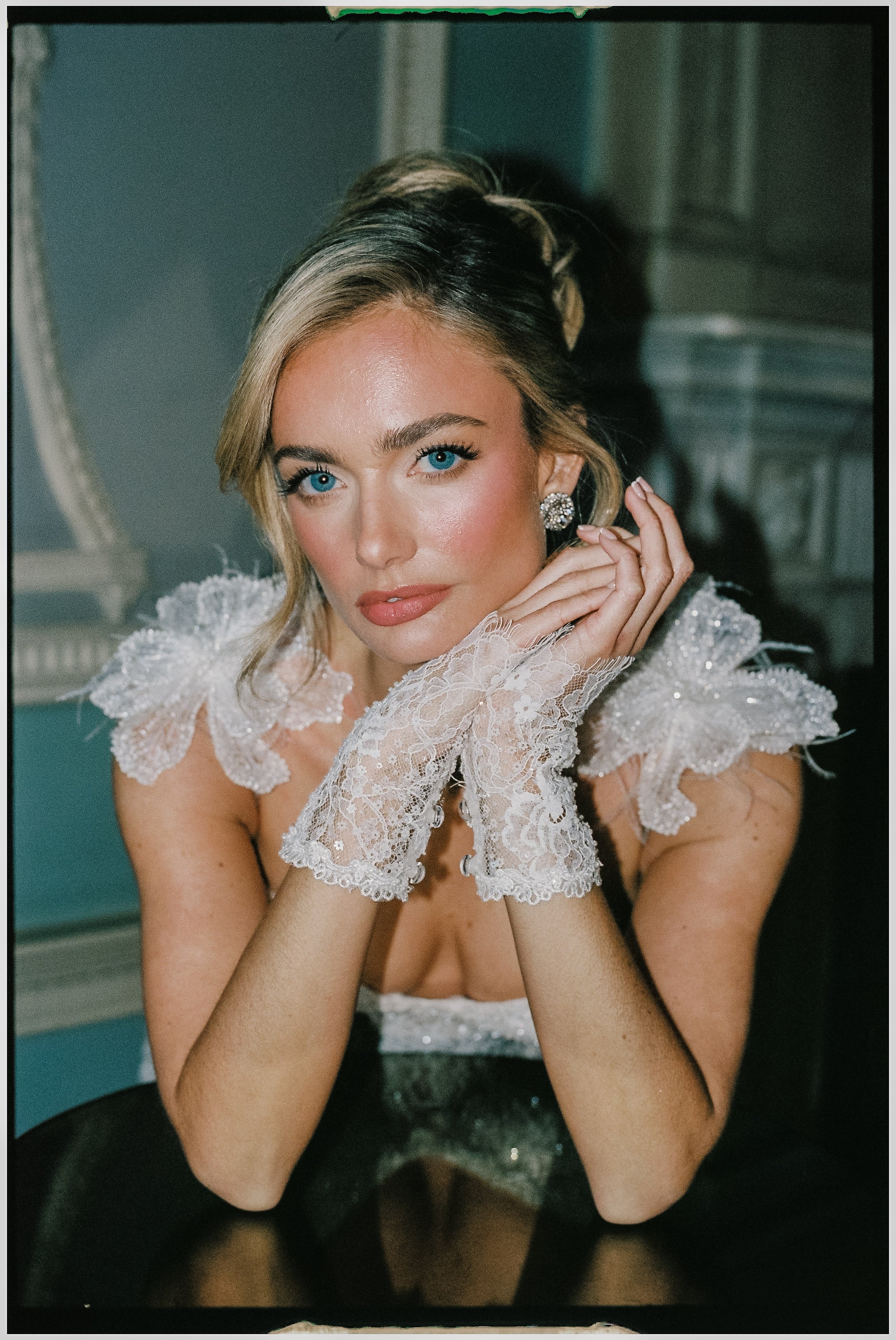 Woman in a Galia Lahav wedding dress with lace gloves against a floral background and wearing sarah gauci wedding earrings