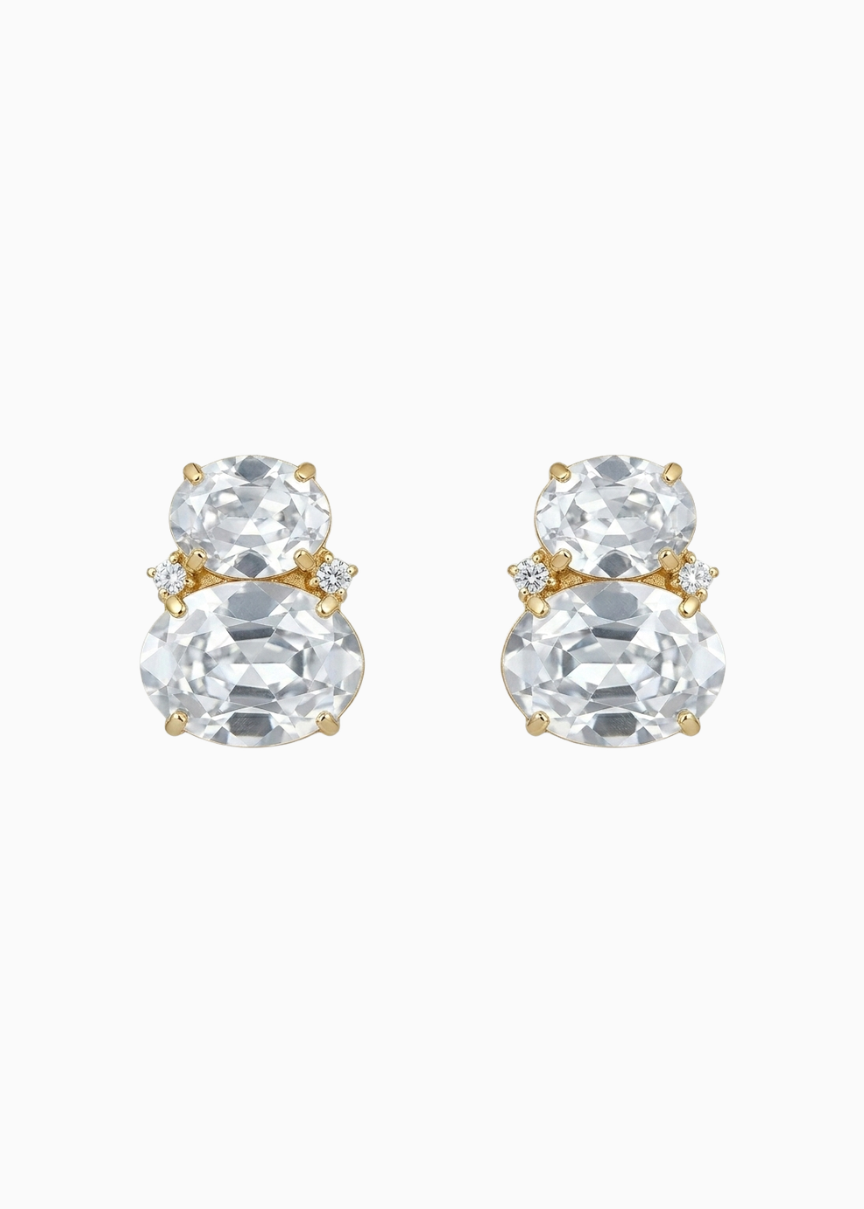 Pair of gold and clear crystal stud earrings on a white background