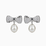 Pair of earrings with bow design and pearl drops on a white background