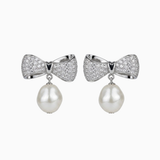 Pair of earrings with bow design and pearl drops on a white background