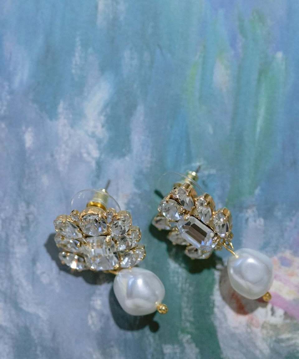 A pair of gold-plated pearl and crystal wedding earrings featuring a cluster of crystals and a baroque pearl drop by Sarah Gauci