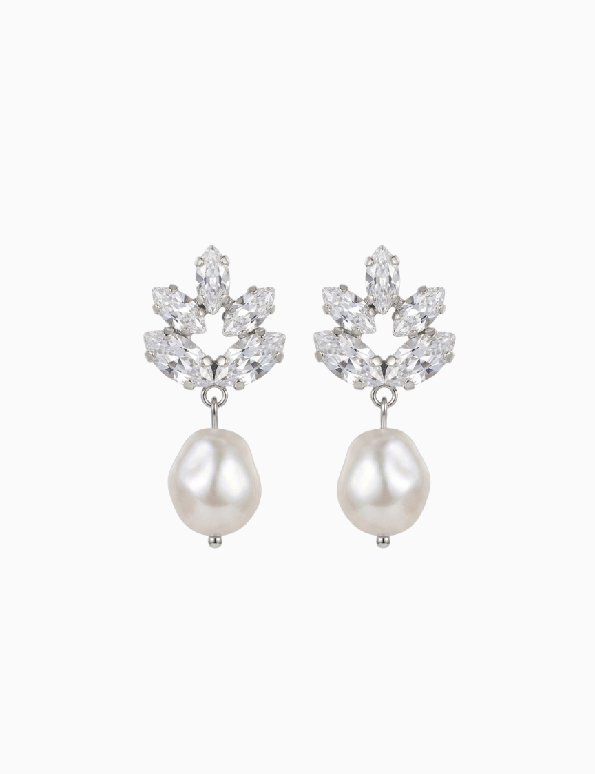 Pair of earrings with pearl drops and floral-like top sections on a white background
