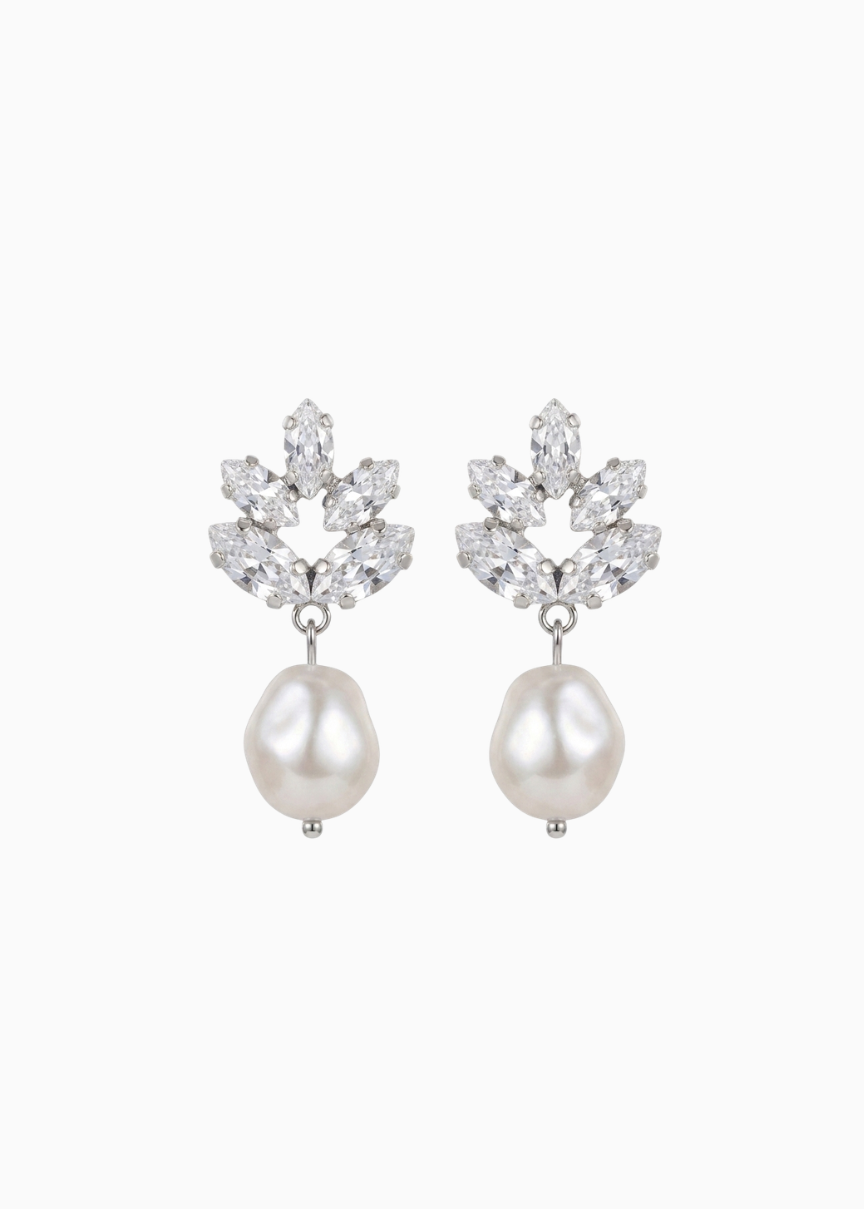 Pair of earrings with pearl drops and floral-like top sections on a white background