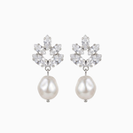 Pair of earrings with pearl drops and floral-like top sections on a white background