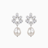Pair of earrings with pearl drops and floral-like top sections on a white background