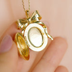 Gold bow-shaped locket on a chain by Sarah Gauci Jewelry Malta