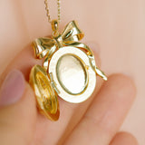 Gold bow-shaped locket on a chain by Sarah Gauci Jewelry Malta