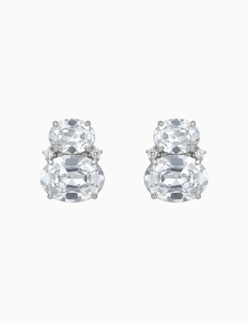 Pair of silver earrings with large clear gemstones on a white background