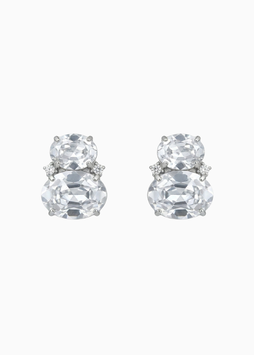 Pair of silver earrings with large clear gemstones on a white background