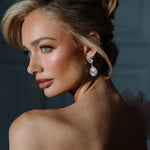 A woman viewed from the back wearing the Philippa Earrings, which are gold-plated with crystals, providing a glamorous and elegant look.