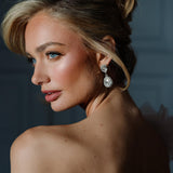A woman viewed from the back wearing the Philippa Earrings, which are gold-plated with crystals, providing a glamorous and elegant look.
