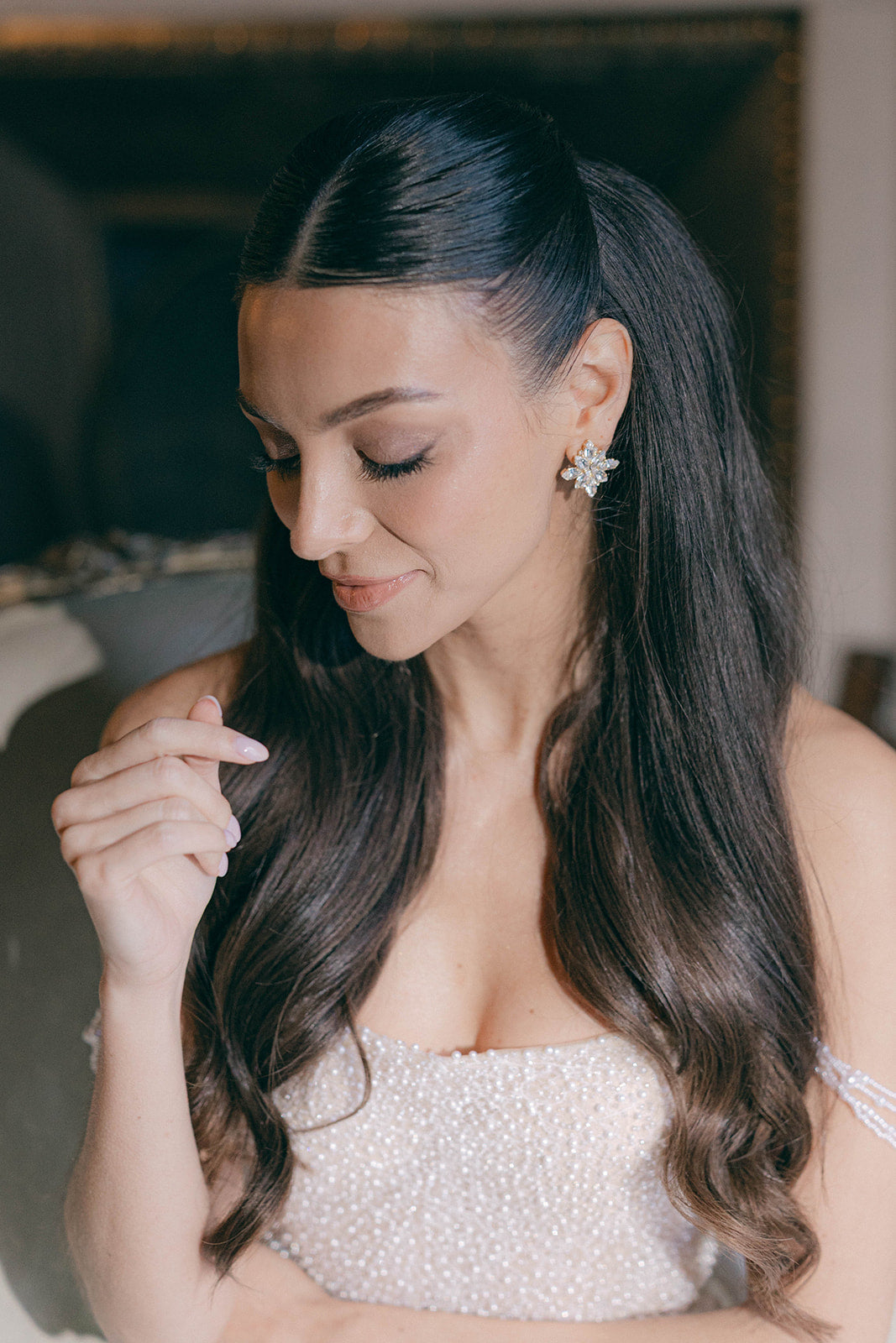 Woman with long dark hair wearing a pearl dress and sarah gauci wedding arrings.