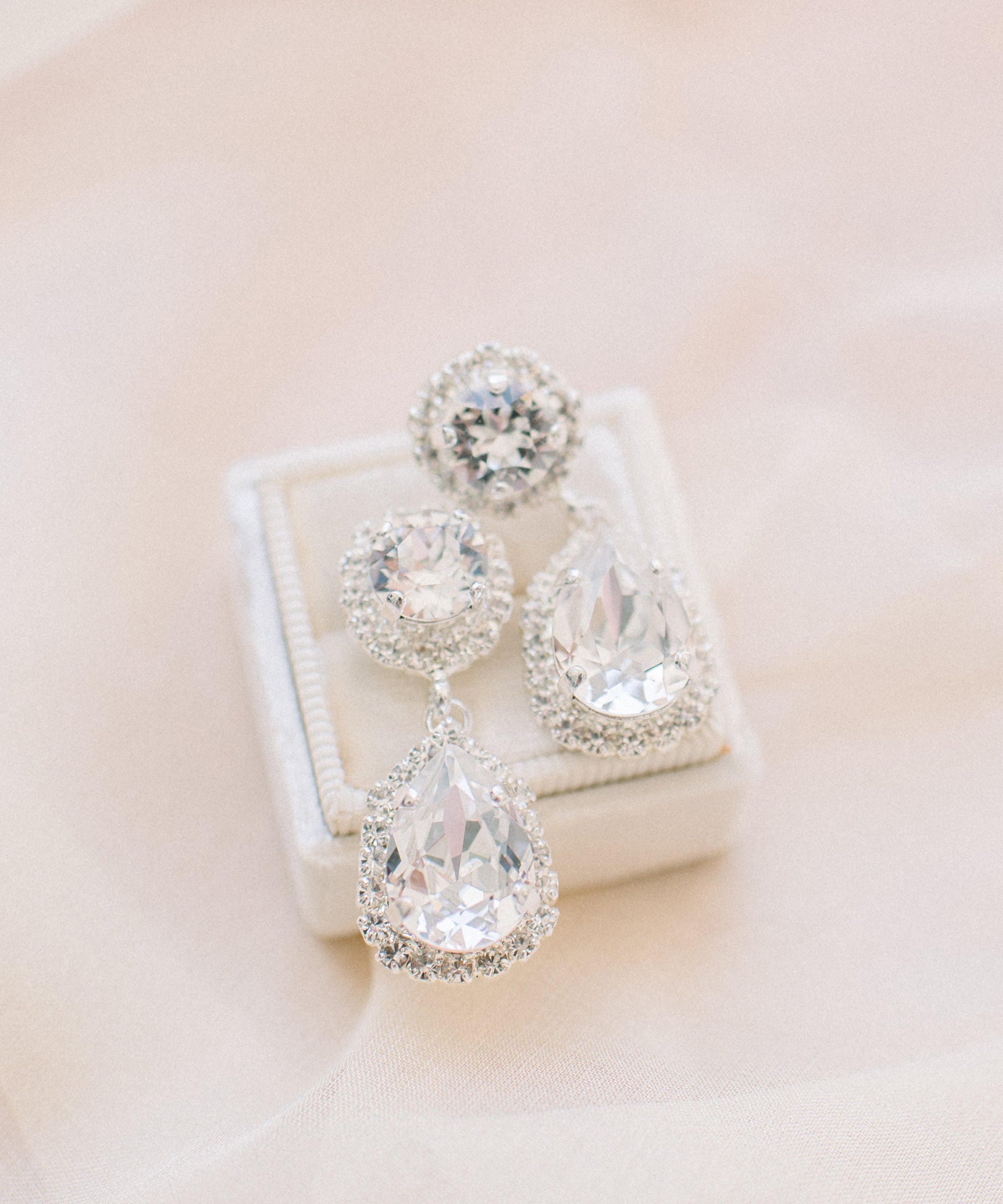A pair of elegant teardrop crystal earrings with intricate halo detailing, perfect for a bride's wedding day look by Sarah Gauci Malta