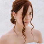 A woman with a soft low-tousled bun wearing The Muse Earrings, which feature cascading crystals. The earrings are 18K gold plated or rhodium plated in Puglia, Italy. Wedding in Italy, Italy Wedding Jewelers, Sposa, 
