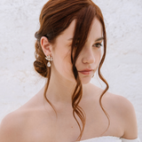 A woman with a soft low-tousled bun wearing The Muse Earrings, which feature cascading crystals. The earrings are 18K gold plated or rhodium plated in Puglia, Italy. Wedding in Italy, Italy Wedding Jewelers, Sposa, 