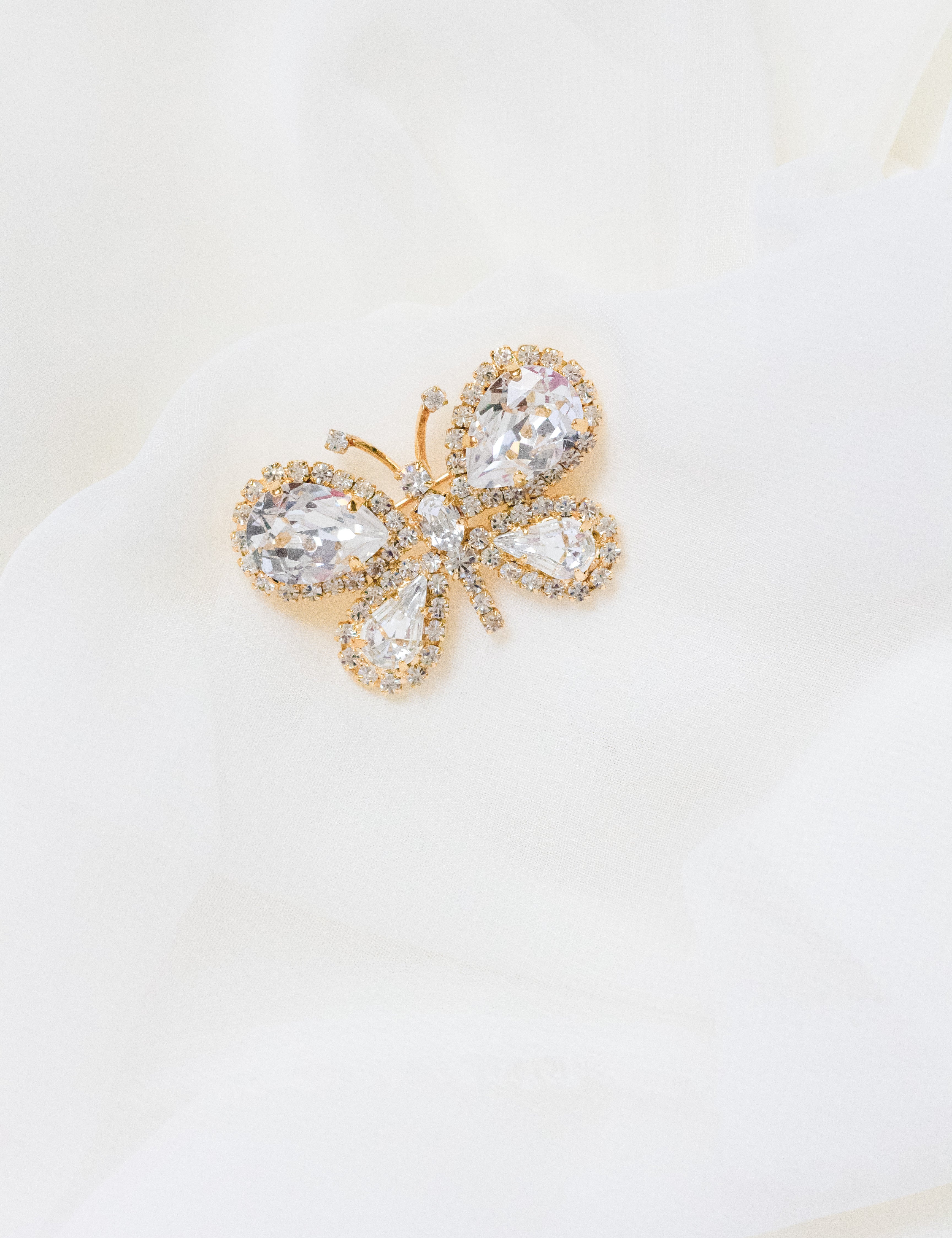 Petunia crystal butterfly brooch by Sarah Gauci, featuring hand-set crystals in an 18K gold-plated setting.